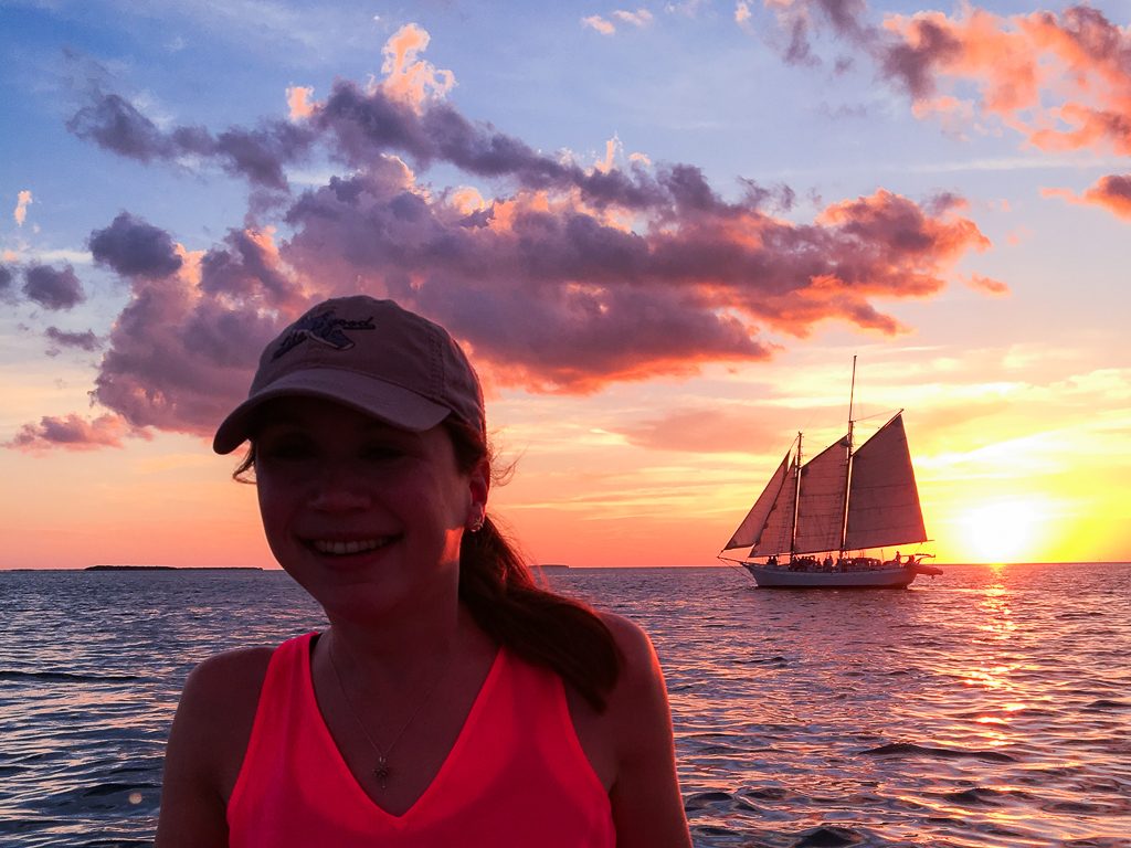 Girl on boat at sunset - How to Travel More