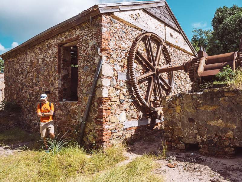 Man standing in front of plantation ruins on St. John's Reef Bay Trail