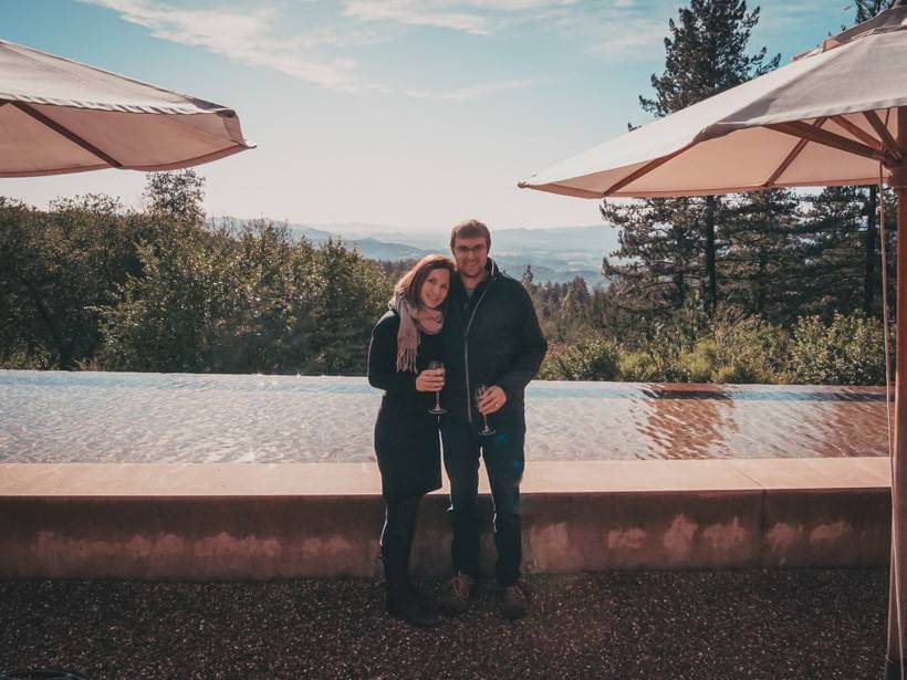 Couple posing in front of the infinity pool and view from Cade Estate Winery on Howell Mountain
