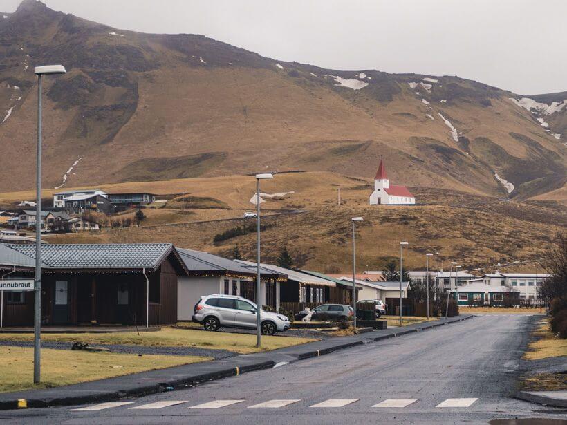 White church with red roof on hill in Vik