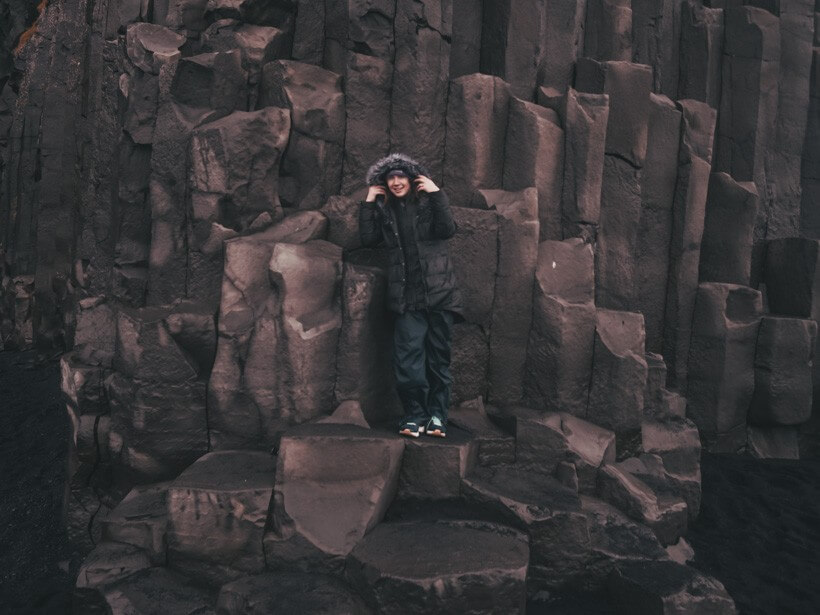 Girl standing on basalt columns on Iceland's south coast