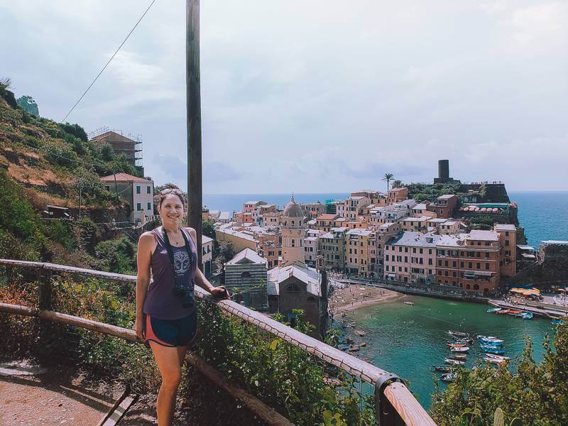 brunette girl in purple tank top standing in front of vernazza on coastal trail - 2 days in cinque terre