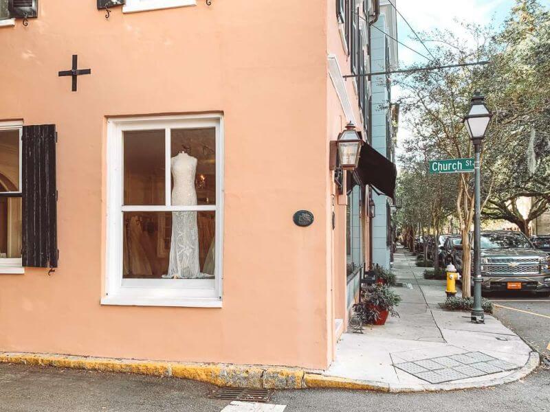 wedding dress hanging in the window of a bridal shop on Church Street - romantic things to do in Charleston SC