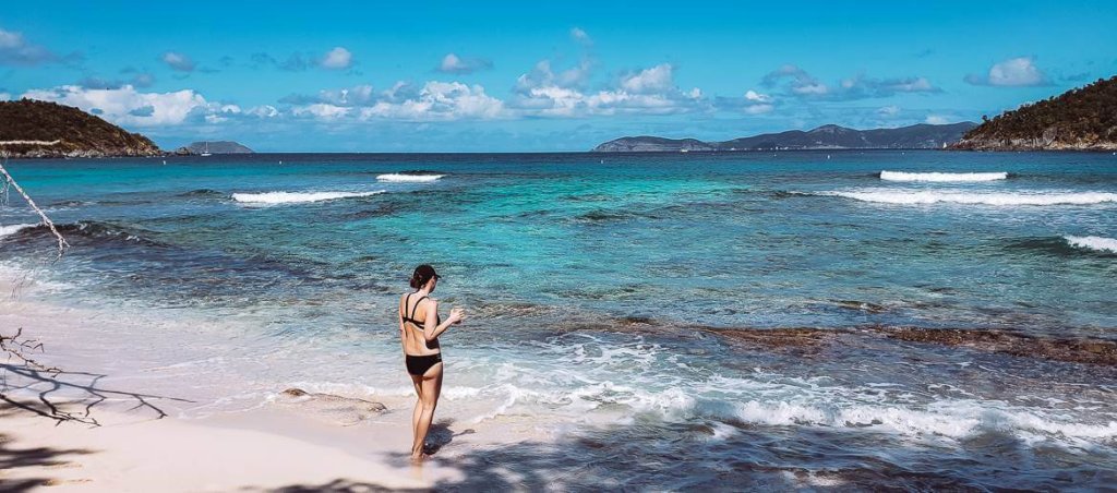 girl in black swimsuit standing on caribbean beach