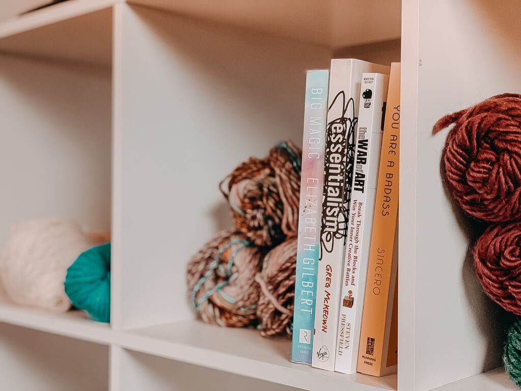 books on shelf with yarn skeins