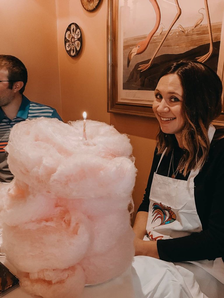 girl sitting at table in front of cotton candy cake at brennan's in new orleans