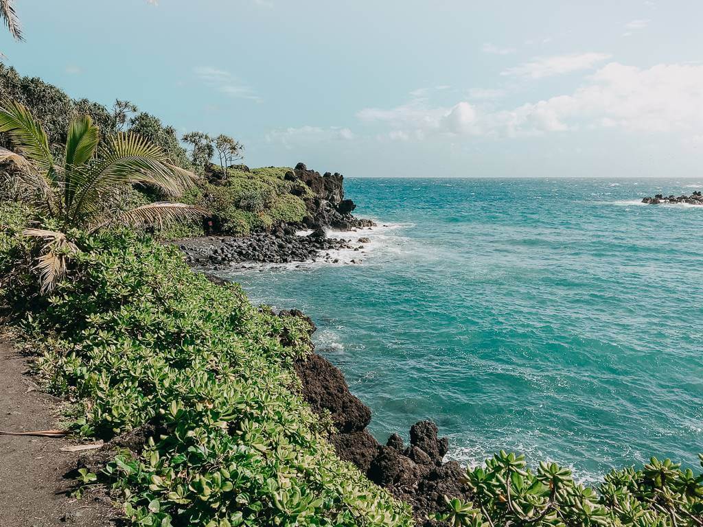 beautiful black rocky coastline against blue pacific ocean in maui