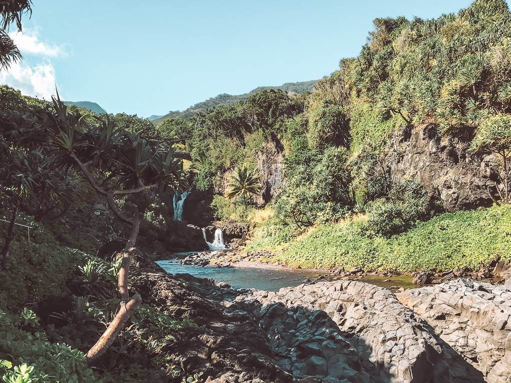 small waterfall in the distance on road to hana in maui