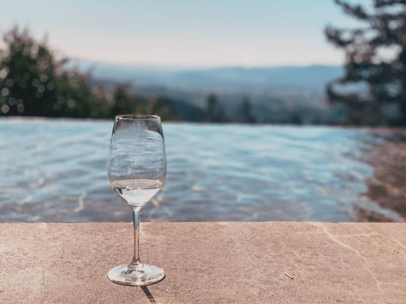 wine glass sitting next to infinity pool looking over napa valley
