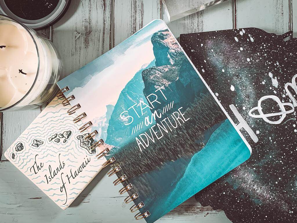 note book and other travel related items sitting on light blue side table