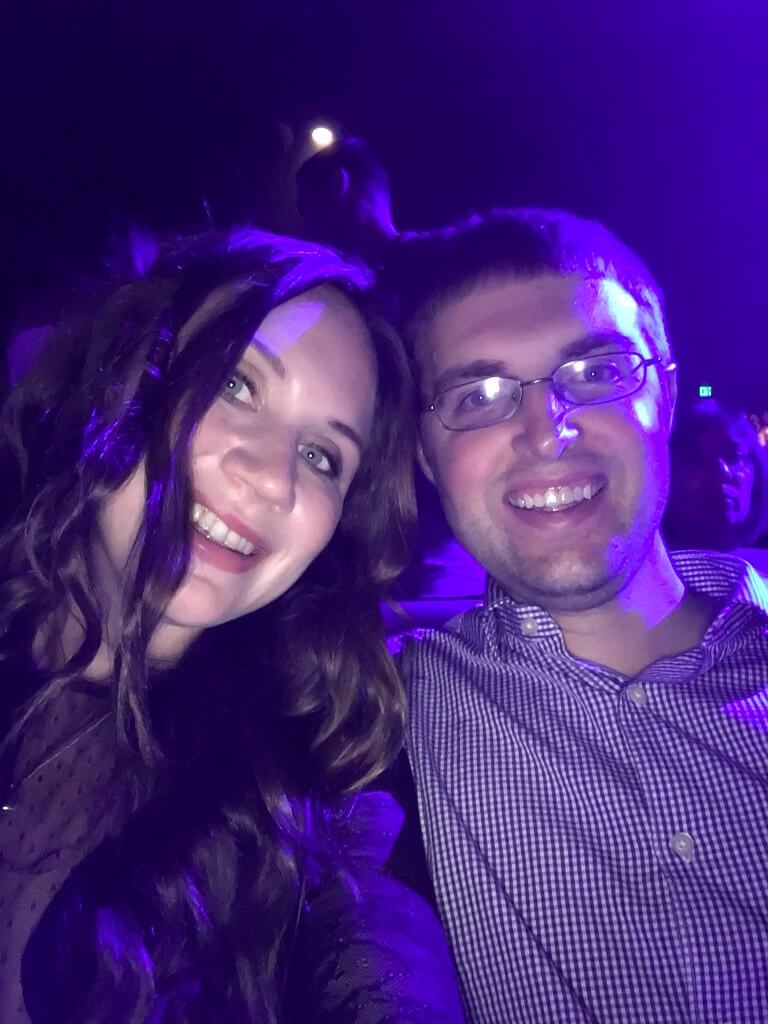 Couple sitting in purple lit crowd for Britney Spears Piece of Me show