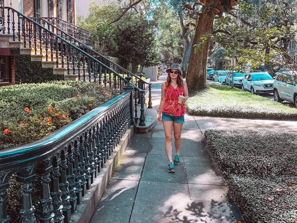 brunette girl holding coffee walking down Jones Street in Savannah GA