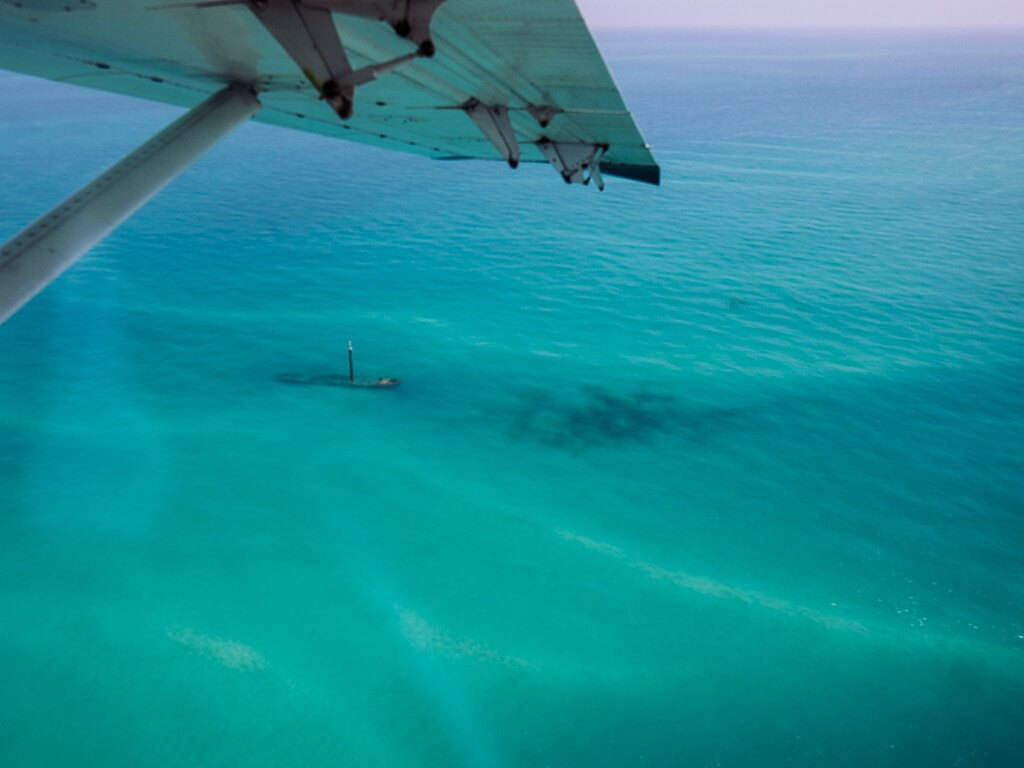 View of shipwreck in turquoise water from the seaplane