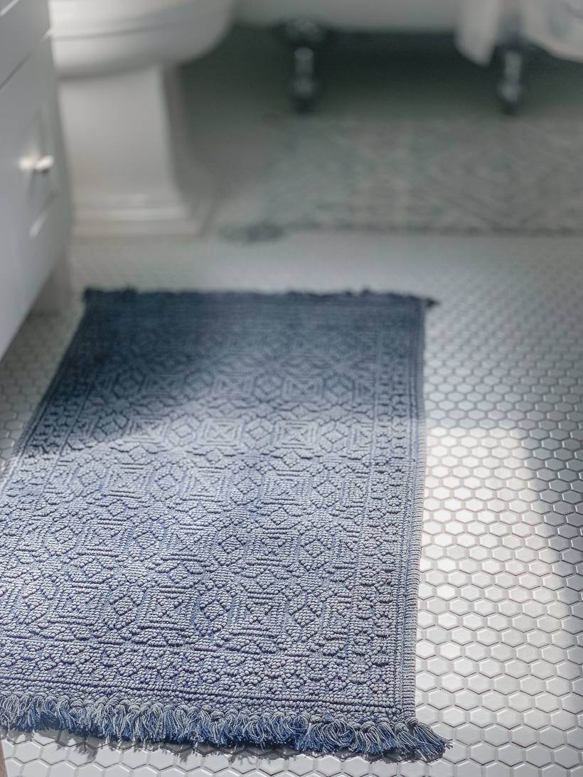 Dark blue rug over white hexagonal tile