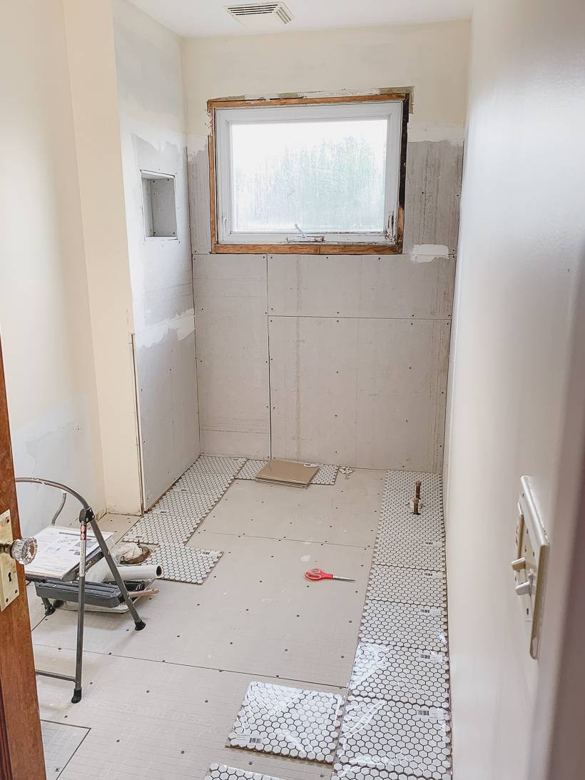 Small hexagonal tile being added to bathroom
