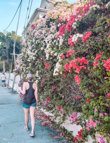 girl walking by wall covered in colorful spring flowers - Key West in April
