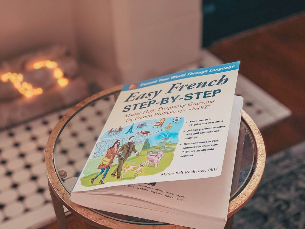French book sitting on small glass table in front of fireplace