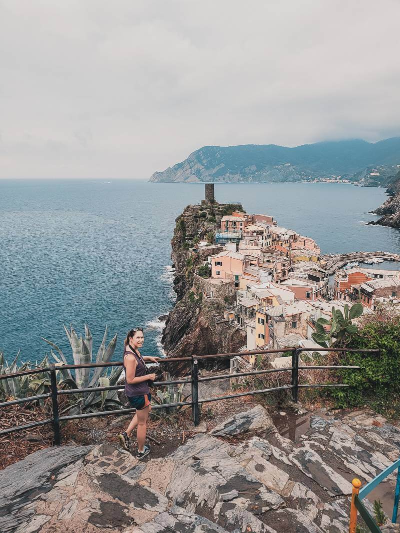 Girl standing on blue trail with view of Vernazza in background - 10 day Italy trip