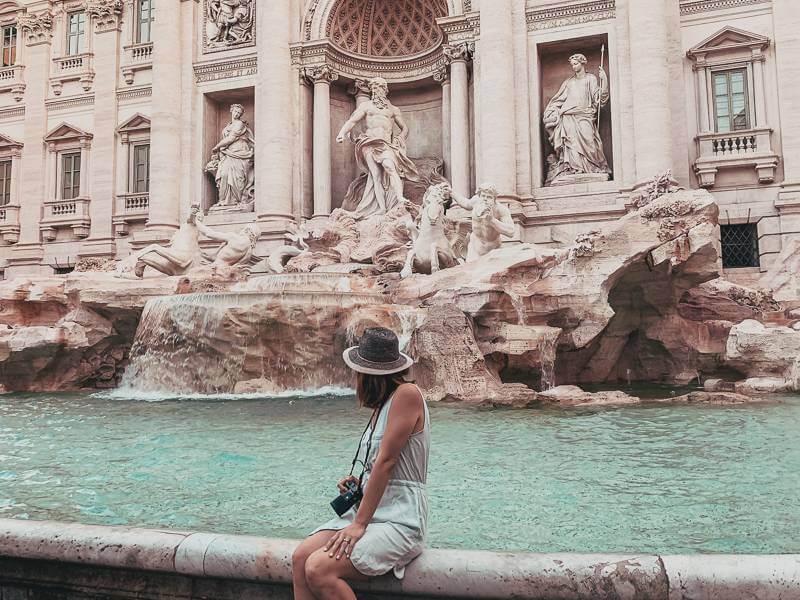 Girl sitting in front of Trevi Fountain in Rome