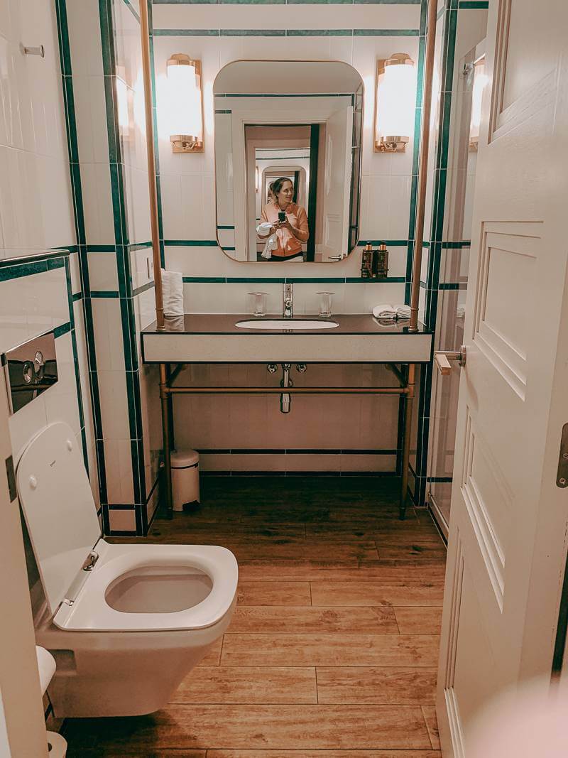 Copper and green detailed bathroom with wide wooden plank floors of H10 Cubik hotel