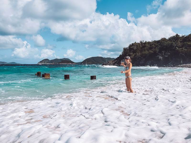 Girl standing in sea foam in Caribbean Sea - best time to visit US Virgin Islands