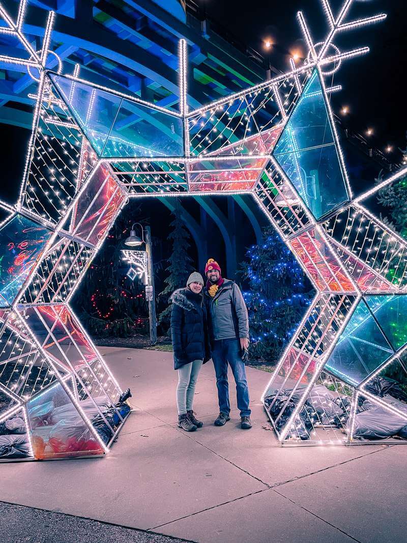 Couple standing under photo spot at Cleveland Zoo Lights at Christmas time