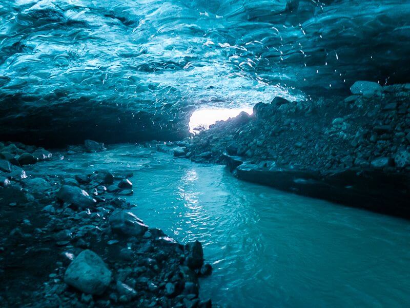 river flowing through blue ice cave in Iceland