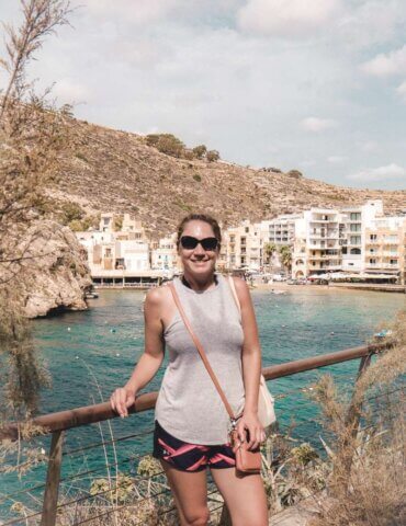Girl standing near pretty resort community while doing solo travel in Malta