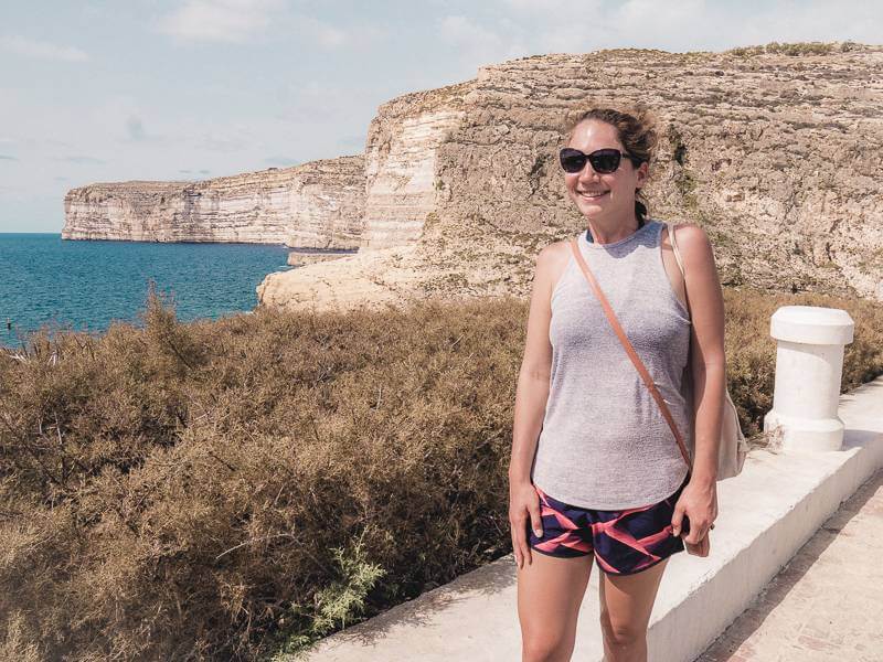 Girl standing in front of white cliffs in Gozo - solo travel Malta