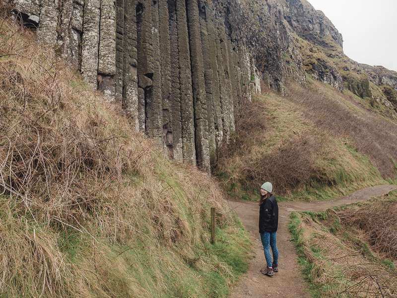 Girl standing near "organ" rock formation on the Giant's Causeway - Antrim Coast Northern Ireland