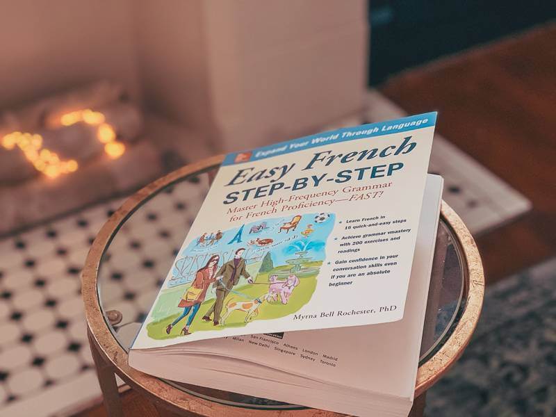 French book sitting on small round glass coffee table - 2022 goals