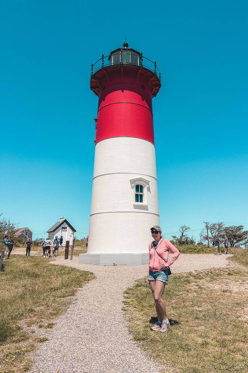 Girl standing in front of red and white Nauset Light