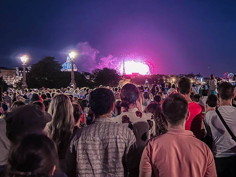 Giant crowd on Pont Neuf watching the fireworks over the Eiffel Tower on Bastille Day in Paris
