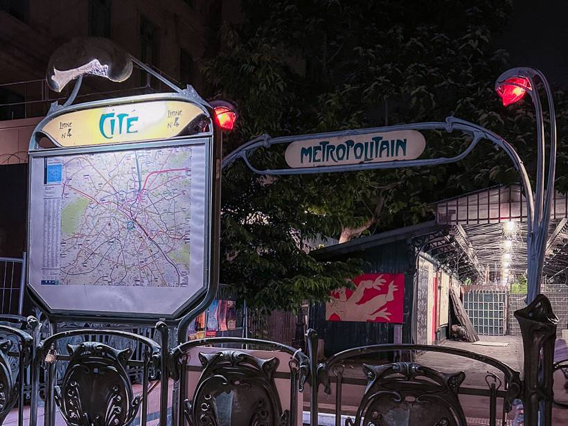 Cite metro station entrance sign in Paris at night