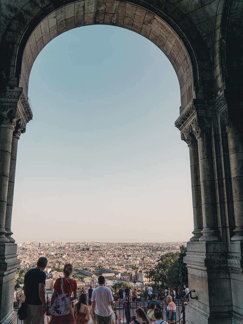 View of Paris skyline from archway in front of Sacre Coeur - Montmartre walk