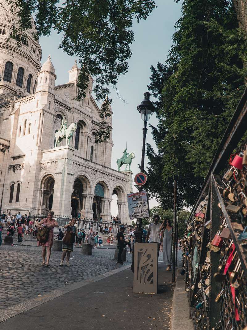 Looking up at facade of Sacre Coeur from fence covered in locks in Montmartre Paris