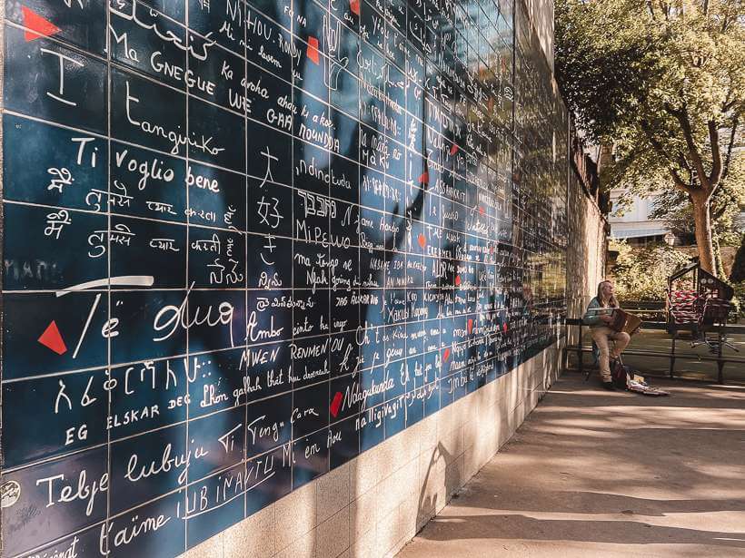 Side view of Love Wall in Montmartre with inscriptions of I love you in every language on dark backdrop