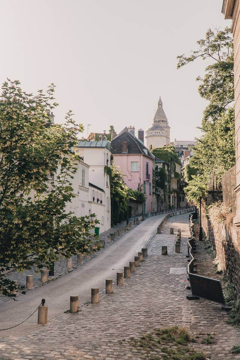 Gorgeous street with Sacre Coeur view and colorful facades during a Montmartre walk in Paris