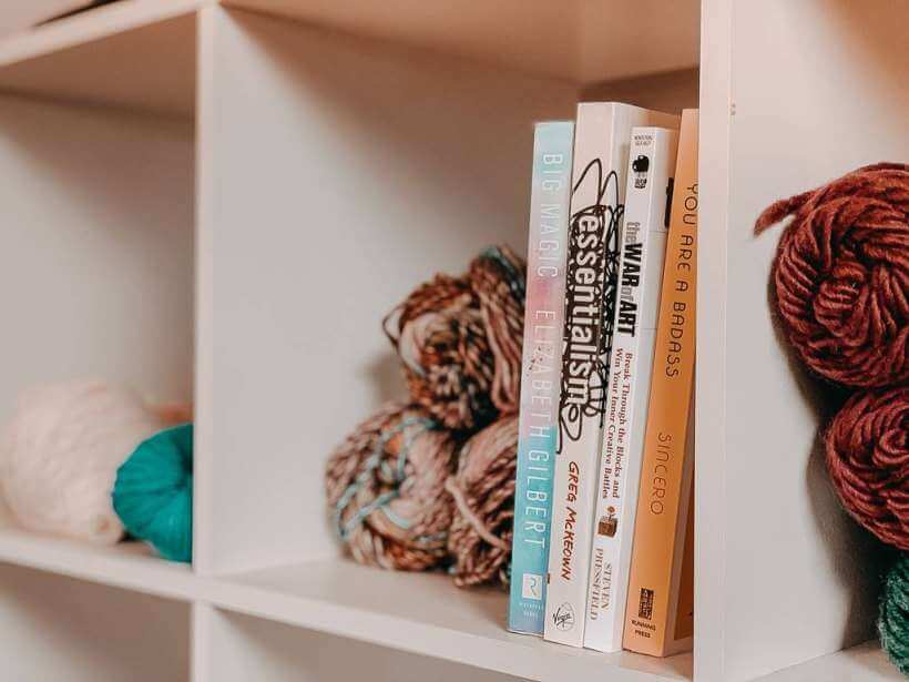 Shelf filled with books and yarn