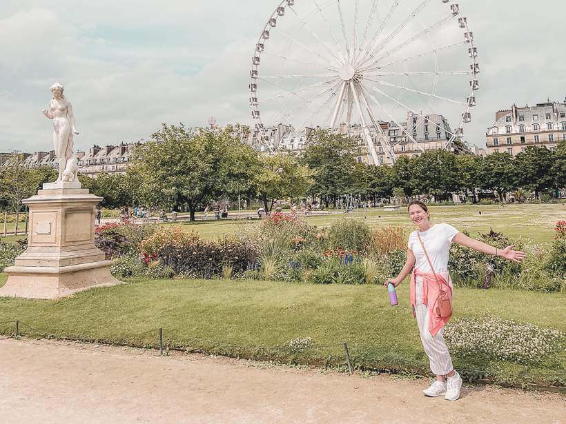 Girl standing in front of famous Ferris wheel in Tuileries Gardens in Paris