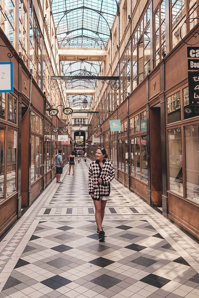 Girl walking through beautiful arcade in Paris