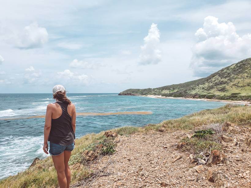 Girl standing at high part of trail overlooking beach on St Croix