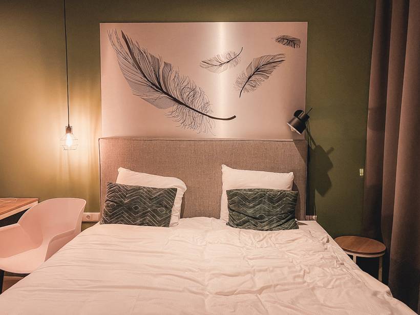 Queen sized bed with art above headboard at Hotel2Stay - Amsterdam trip cost
