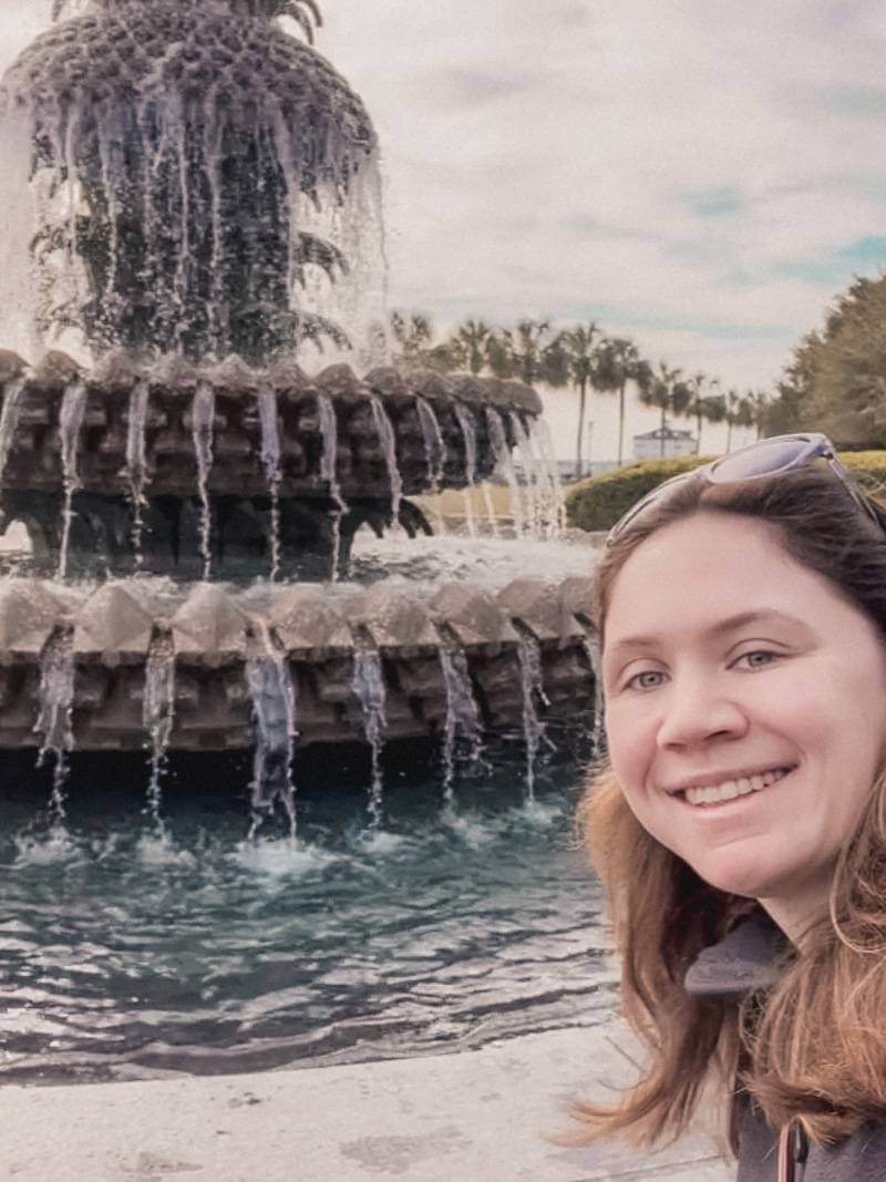 Girl taking selfie in front of pineapple fountain in Charleston SC - solo trip to Charleston, SC