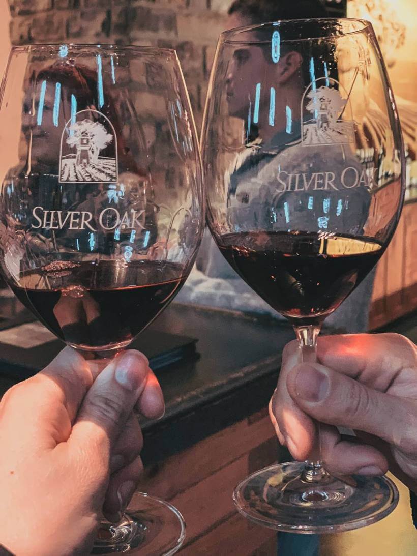 couple clinking glasses of red wine glasses together