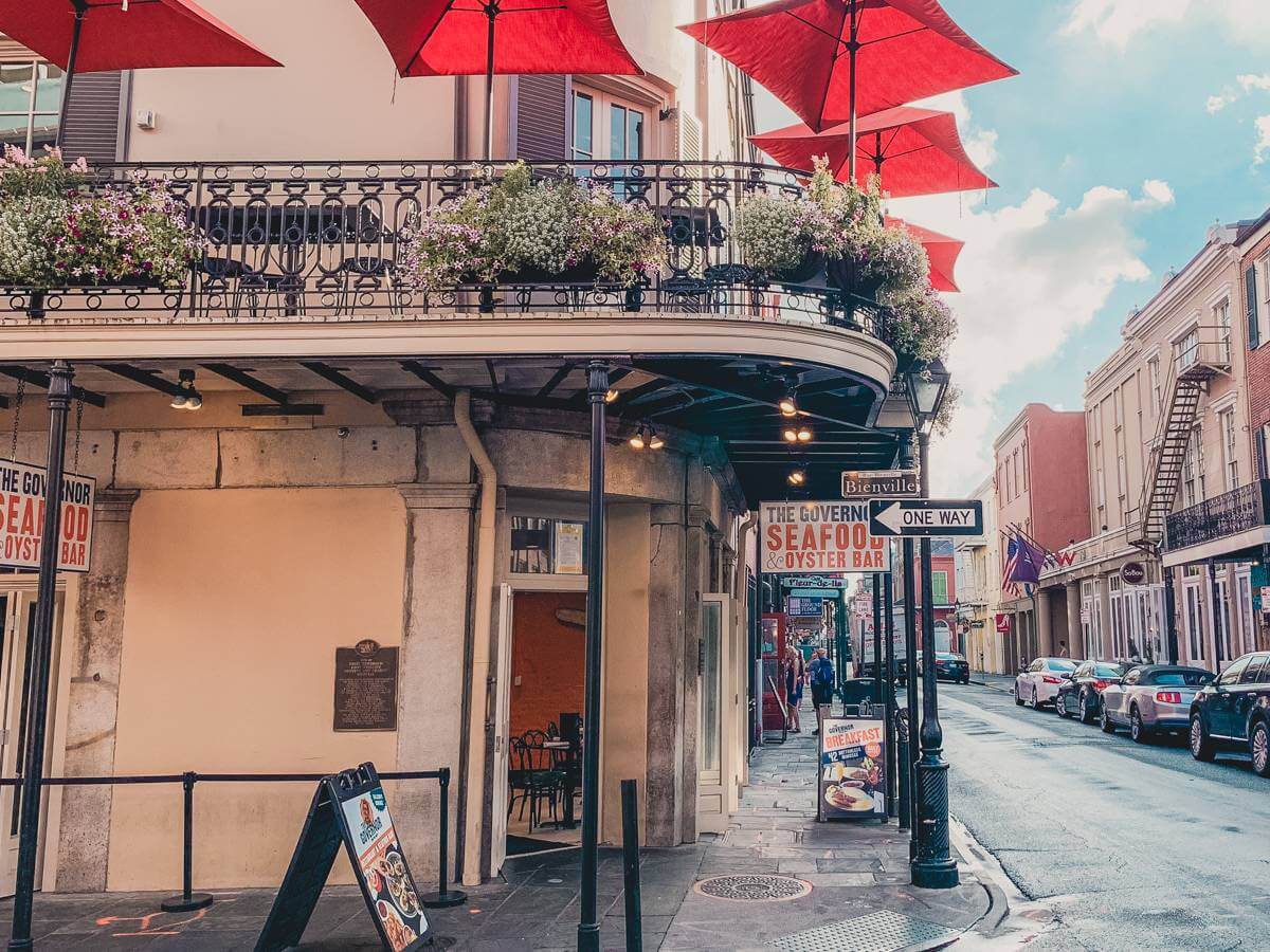 bright colored buildings and balconies lined with flowers in new orleans french quarter