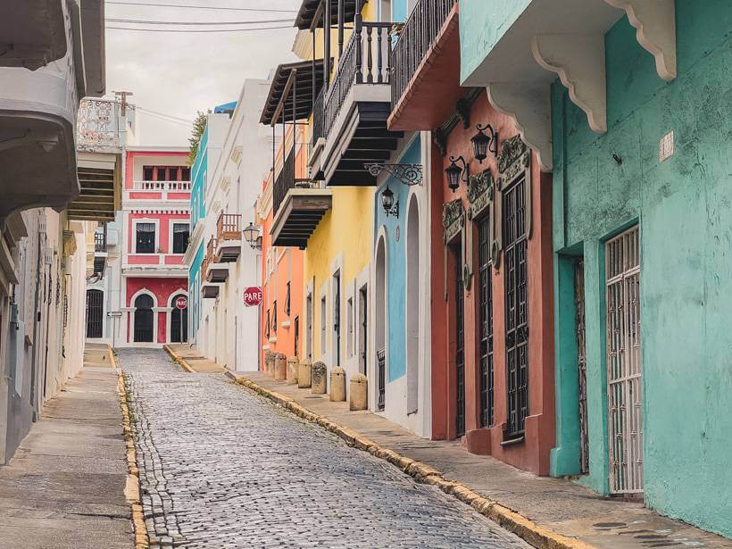 Colorful buildings along blue cobblestone street in Puerto Rico