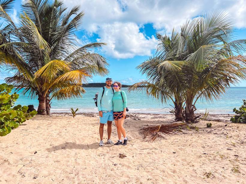 Couple standing between palm trees at beach in Vieques, Puerto Rico