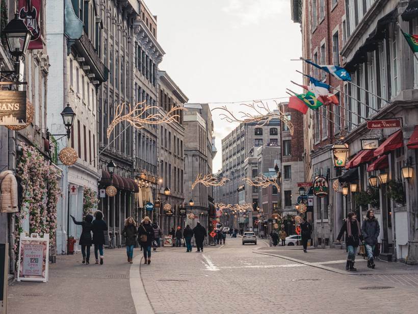 Lively street in Old Montreal decorated for Christmas - solo travel Montreal