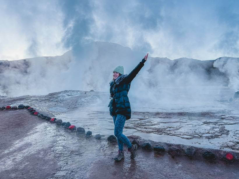 Girl dancing in the mist at the Tatio geyser field - Chile trip cost